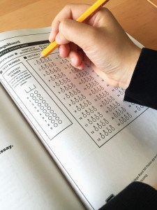 Photo of a student's hand filling in multiple choice bubbles. 